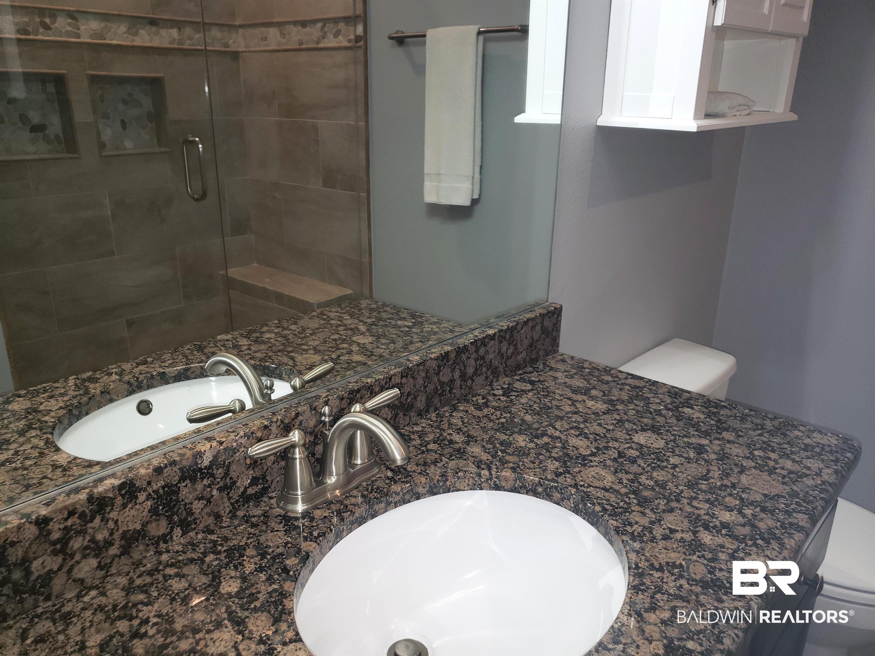 23373 Dundee Circle Foley, AL 36535 - Photo 18 of 34 Bathroom with vanity, an enclosed shower, and toilet