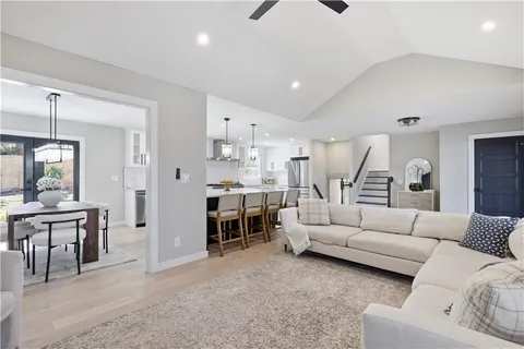 a living room with furniture and a dining table with kitchen view