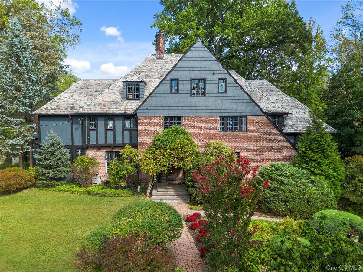 Bright Tudor in beautiful Greenhaven neighborhood, with inviting mature perennial flowering gardens