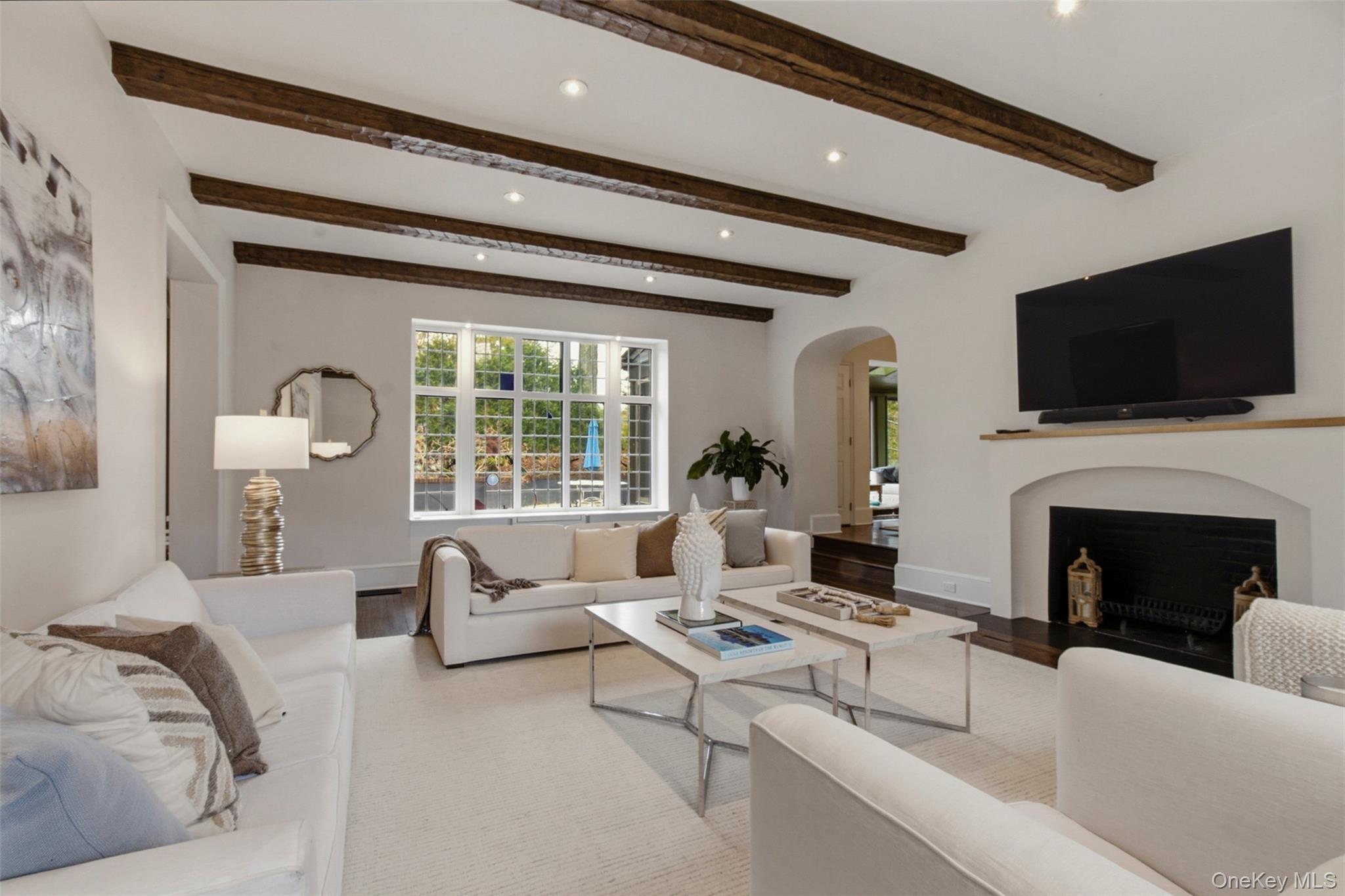 9 Rye Road Rye, NY 10580 - Photo 6 of 50 Living room showcasing striking beamed ceilings and a wood-burning fireplace.