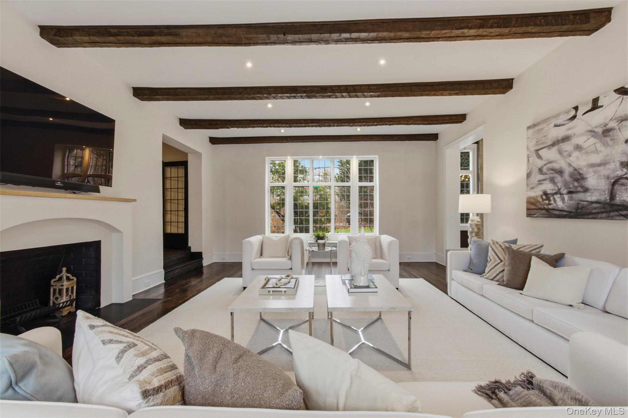 9 Rye Road Rye, NY 10580 - Photo 7 of 50 Living room showcasing striking beamed ceilings and a wood-burning fireplace.