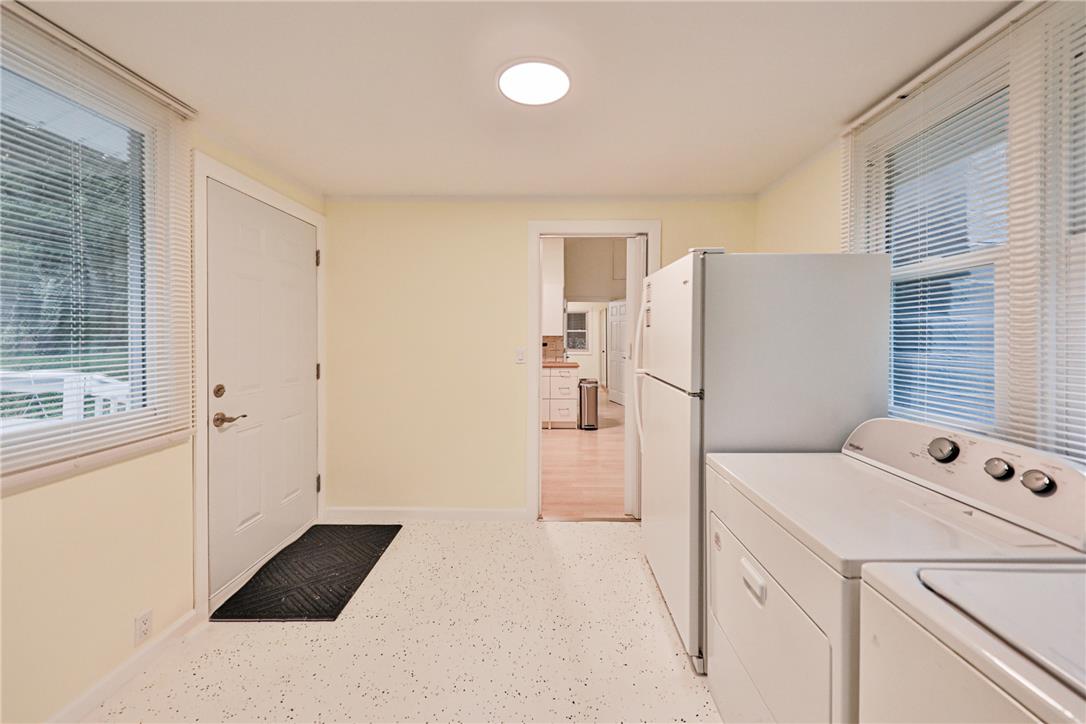 5599 Minks Pond Road Bushkill, PA 18324 - Photo 21 of 64 A well-lit utility room with convenient laundry appliances and easy outdoor access.