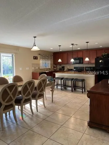 a open kitchen with stainless steel appliances granite countertop a table and chairs