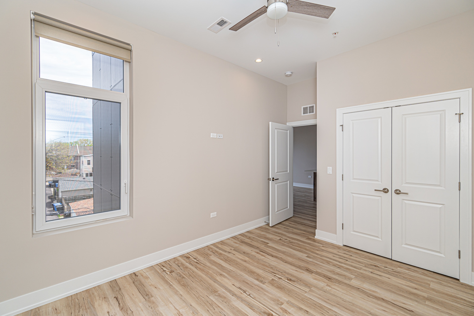 4149 South Cottage Grove Avenue, Unit 305 Chicago, IL 60653 - Photo 13 of 27 a view of an empty room with wooden floor and a window