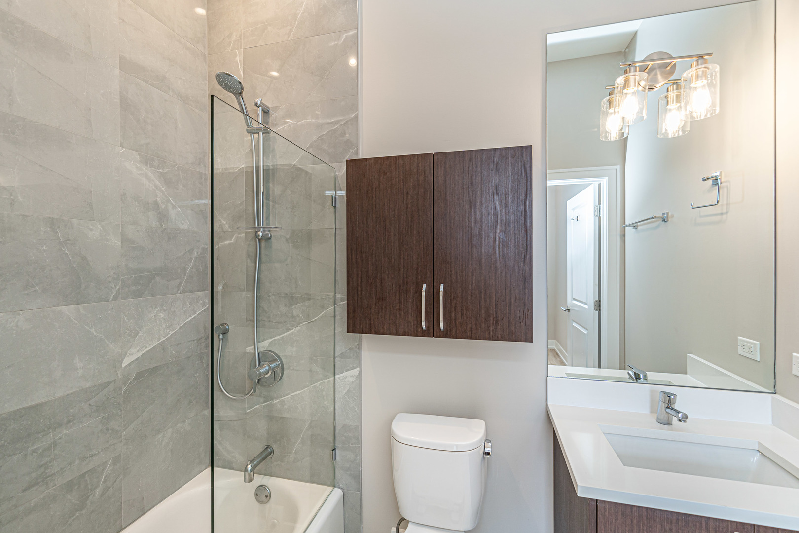 4149 South Cottage Grove Avenue, Unit 305 Chicago, IL 60653 - Photo 14 of 27 a bathroom with a shower a sink a toilet and a mirror