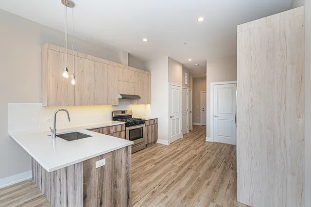 a kitchen with a sink a refrigerator and wooden floor