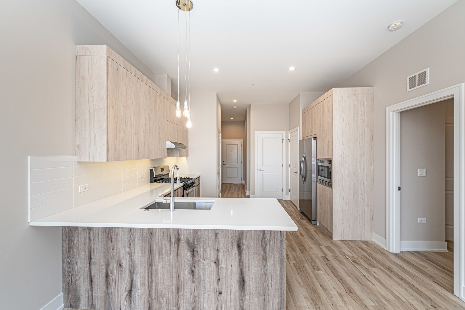 4149 South Cottage Grove Avenue, Unit 305 Chicago, IL 60653 - Photo 20 of 27 a kitchen with a sink a refrigerator and wooden floor