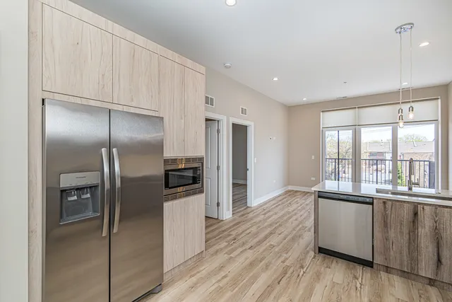 a kitchen with stainless steel appliances granite countertop a refrigerator and a sink