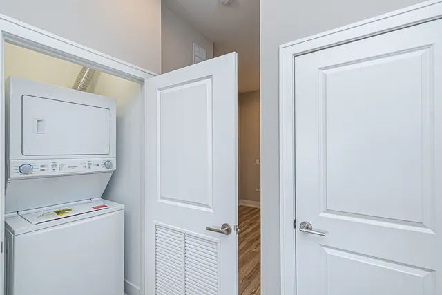 a view of a hallway with wooden floor and closet area