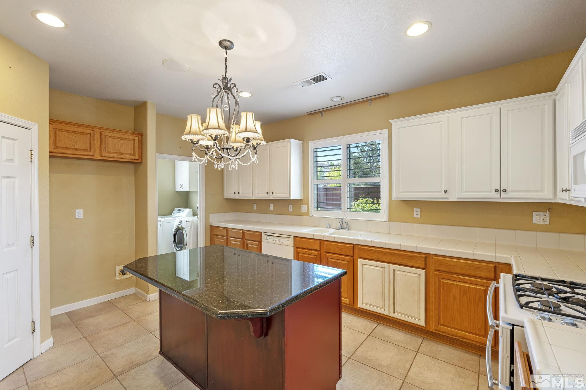 10568 Iron Point Circle Reno, NV 89521 - Photo 14 of 30 a kitchen with stainless steel appliances granite countertop a sink a stove and a refrigerator