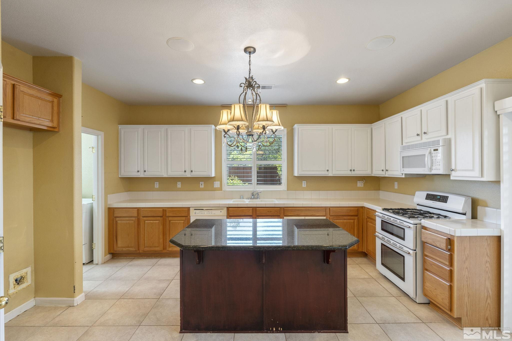 10568 Iron Point Circle Reno, NV 89521 - Photo 17 of 30 a kitchen with a stove a sink a counter space and cabinets