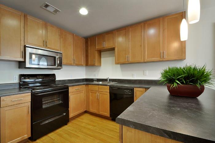 711 West 32nd Street, Unit 105 Austin, TX 78705 - Photo 5 of 11 a kitchen with stainless steel appliances granite countertop a stove a sink a microwave and cabinets