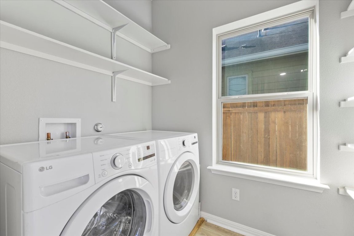 4524 Kind Way, Unit 257 Austin, TX 78725 - Photo 13 of 16 Washroom with washer and dryer and light wood finished floors