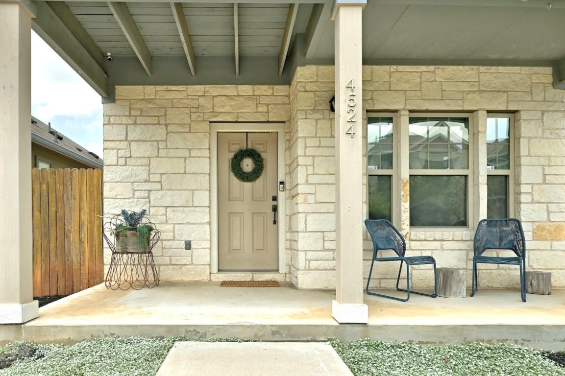 4524 Kind Way, Unit 257 Austin, TX 78725 - Photo 15 of 16 Doorway to property featuring stone siding and a porch