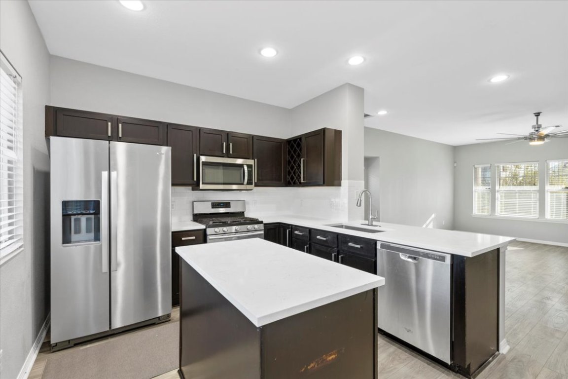 4524 Kind Way, Unit 257 Austin, TX 78725 - Photo 16 of 16 Kitchen featuring plenty of natural light, stainless steel appliances, a kitchen island, open floor plan, and recessed lighting