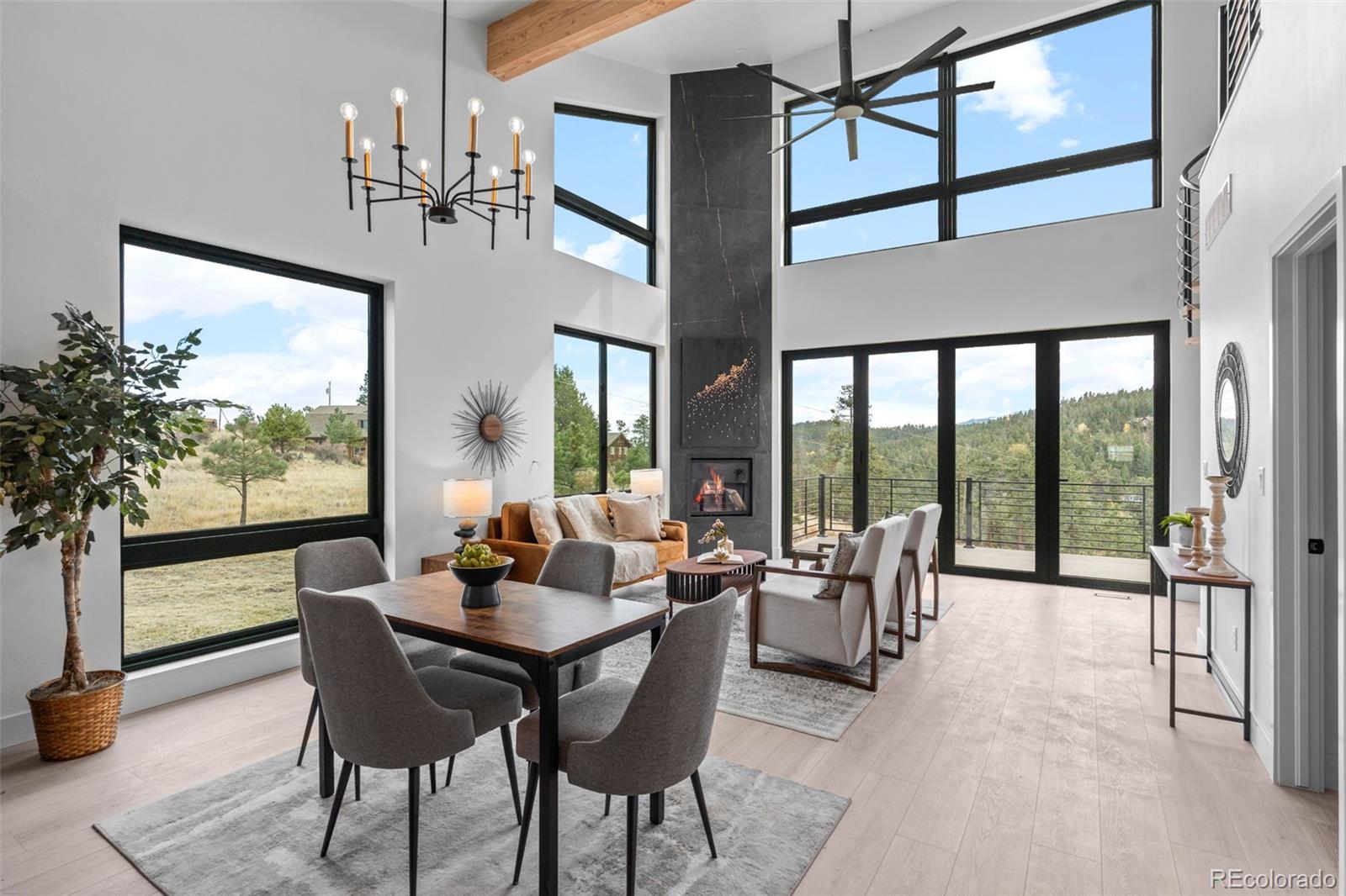 542 Conifer Drive Bailey, CO 80421 - Photo 13 of 47 a dining room with furniture large windows and a chandelier