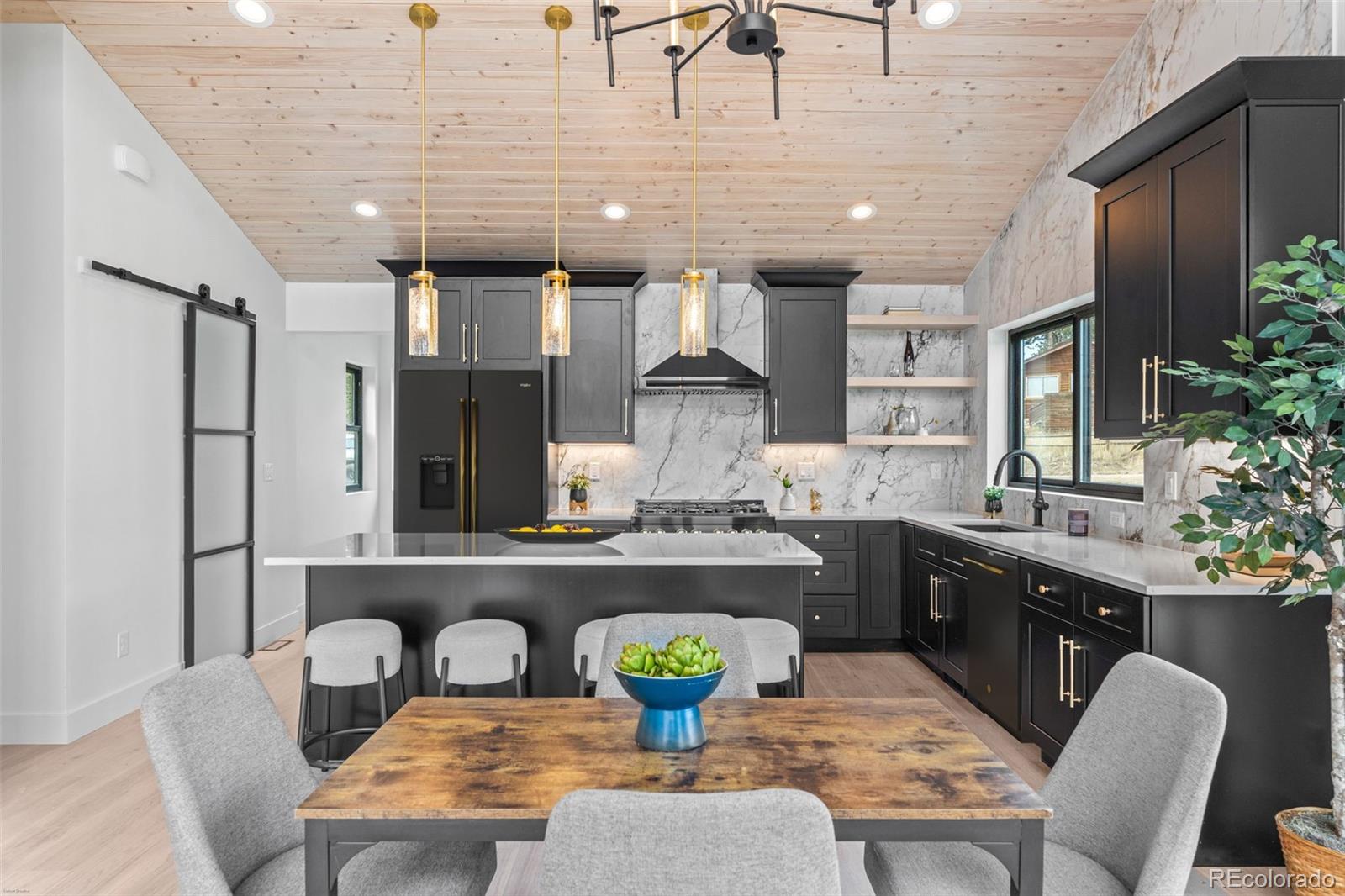 542 Conifer Drive Bailey, CO 80421 - Photo 19 of 47 a kitchen with a kitchen island a stove a table and chairs