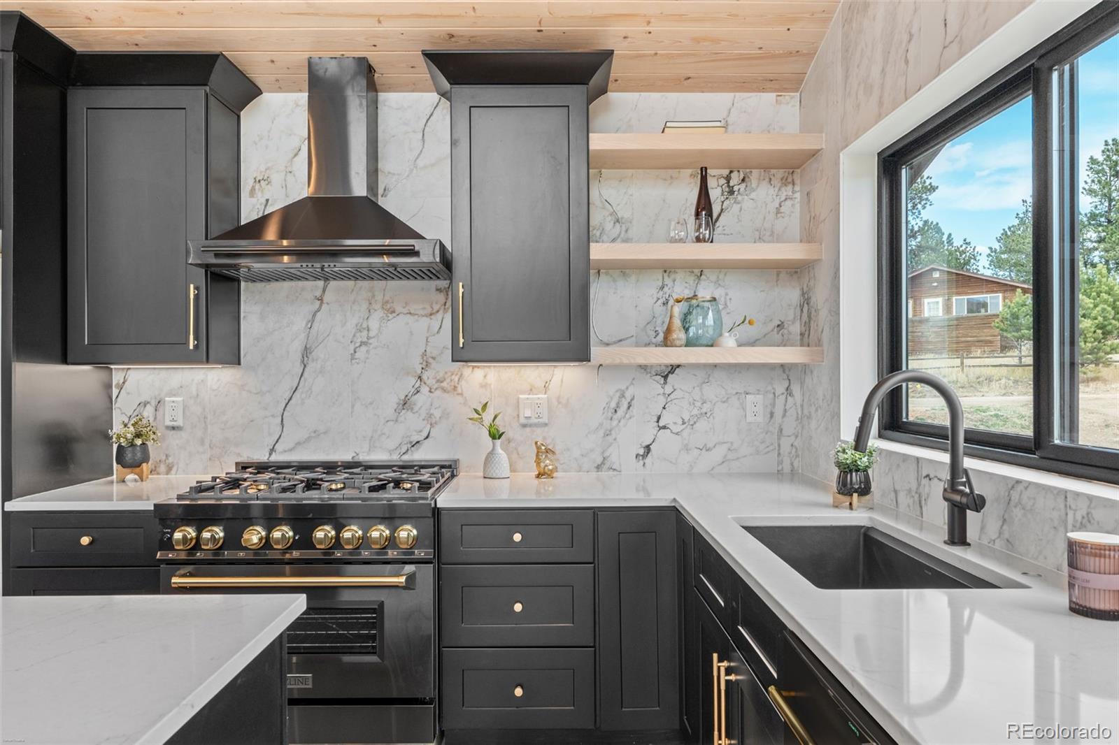 542 Conifer Drive Bailey, CO 80421 - Photo 22 of 47 a kitchen with stainless steel appliances a sink stove and cabinets