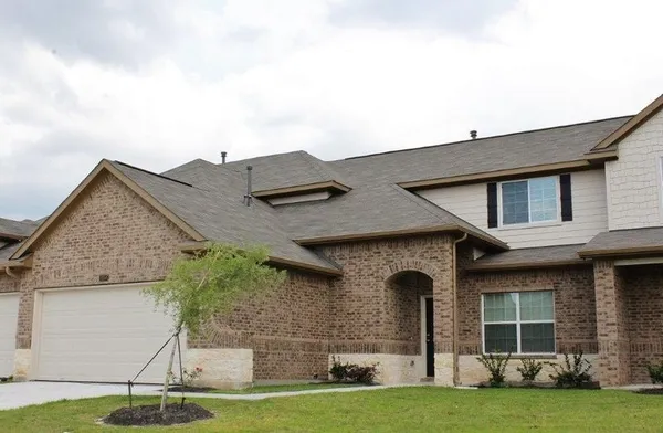 a front view of a house with a garden and yard