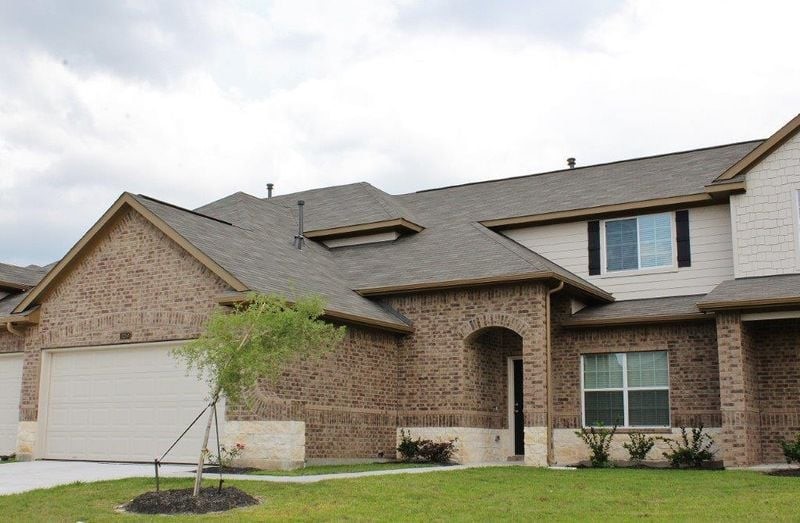 a front view of a house with a garden and yard