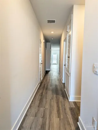 a view of hallway with wooden floor