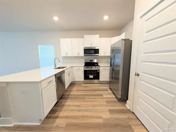 a large kitchen with cabinets and stainless steel appliances