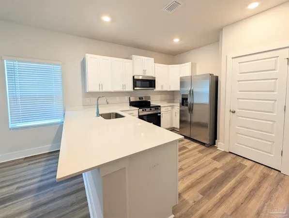 a kitchen with stainless steel appliances a refrigerator and a stove top oven