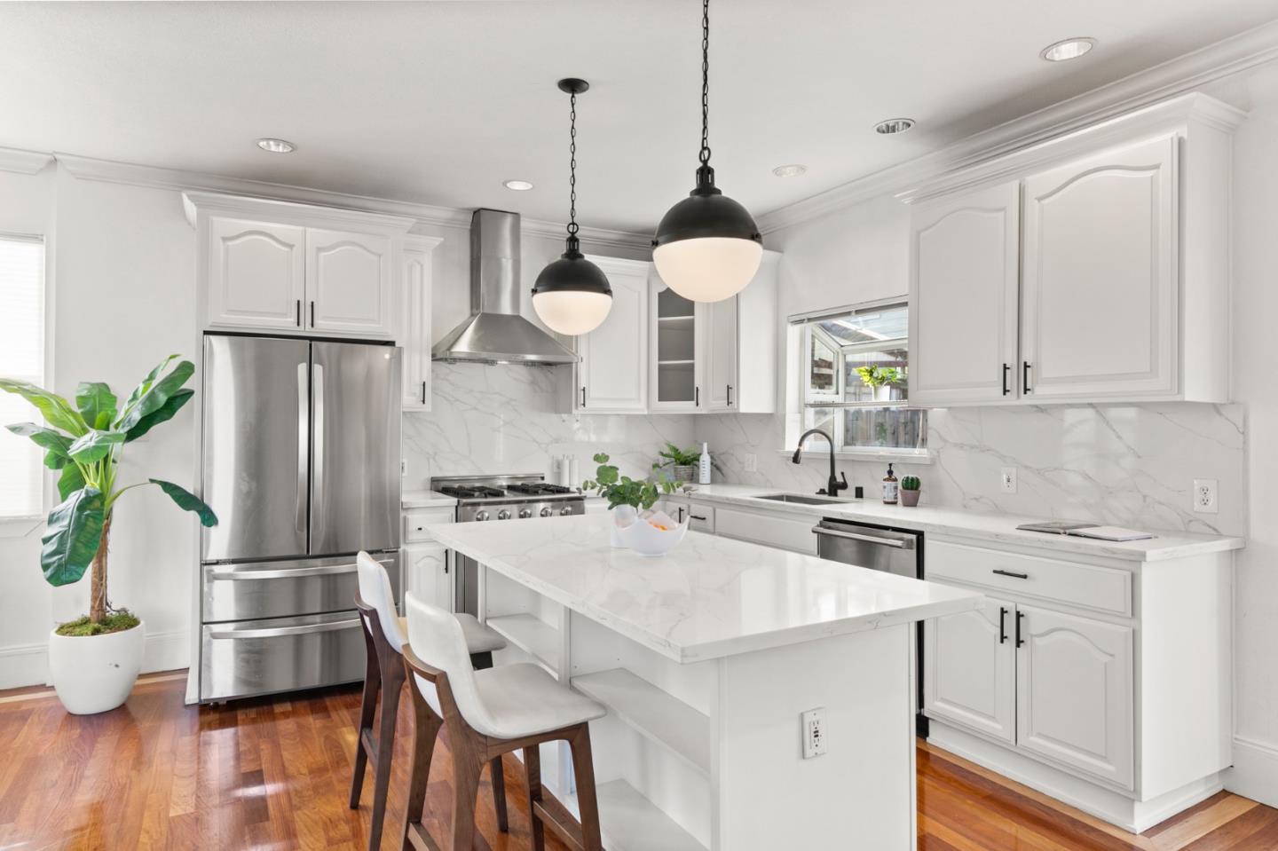1095 Wright Avenue Mountain View, CA 94043 - Photo 10 of 29 a kitchen with stainless steel appliances a dining table chairs stove and white cabinets