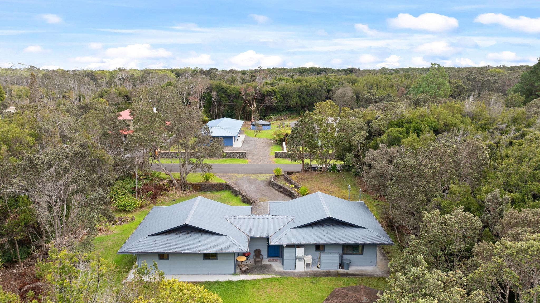 99-1817 Painiu Loop Volcano, HI 96785 - Photo 24 of 30 a aerial view of a house with a yard wooden table and chairs