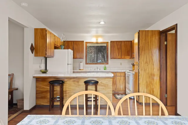 a kitchen with granite countertop a sink a stove and a wooden floors