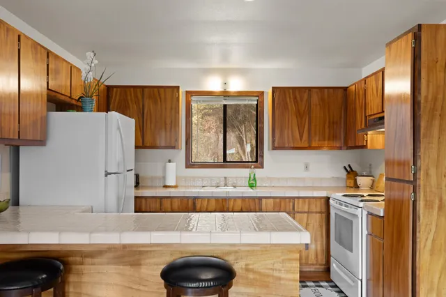 a kitchen with a sink a refrigerator and cabinets