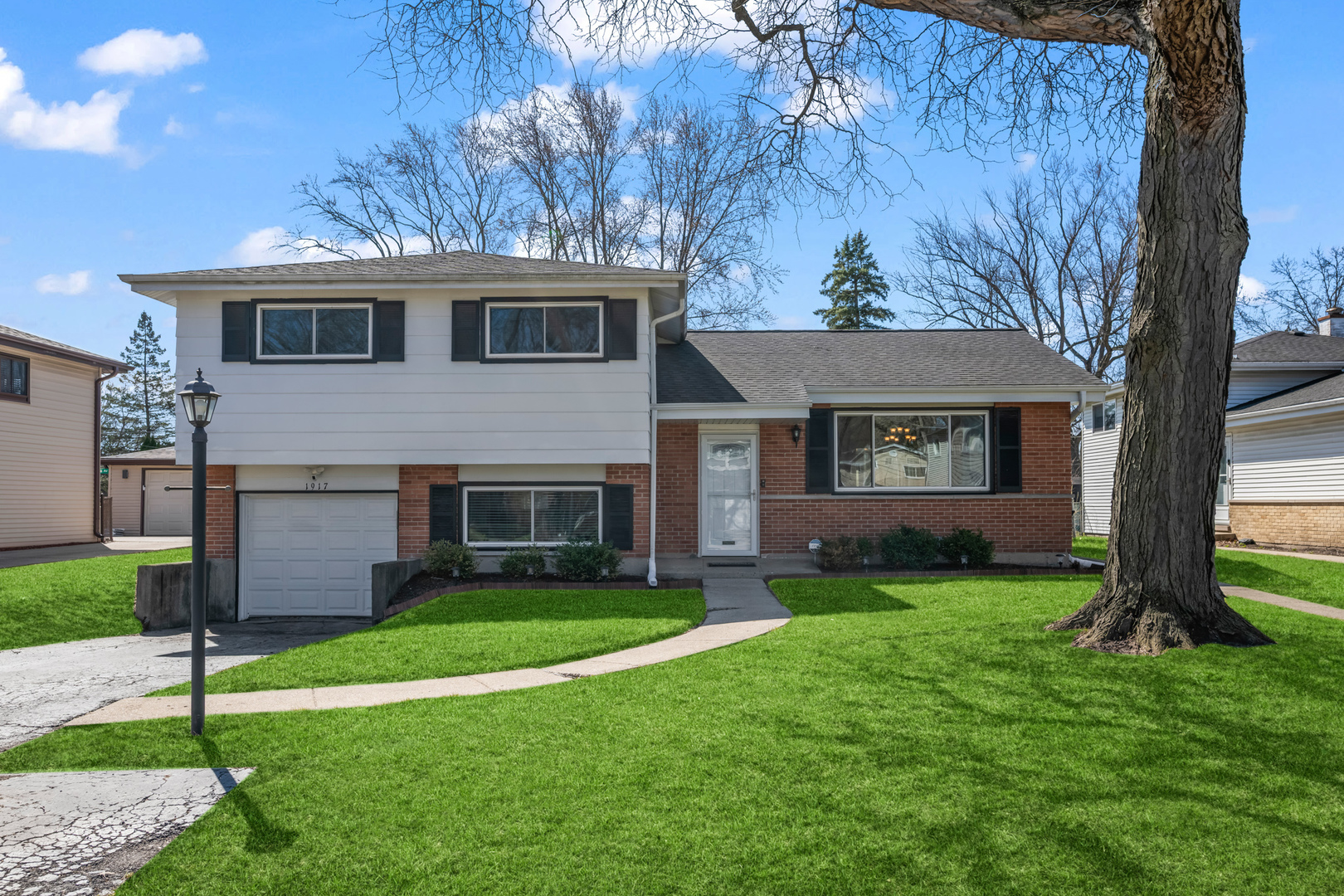 1917 Pawnee Lane Mount Prospect, IL 60056 - Photo 1 of 29 a front view of a house with a garden and yard