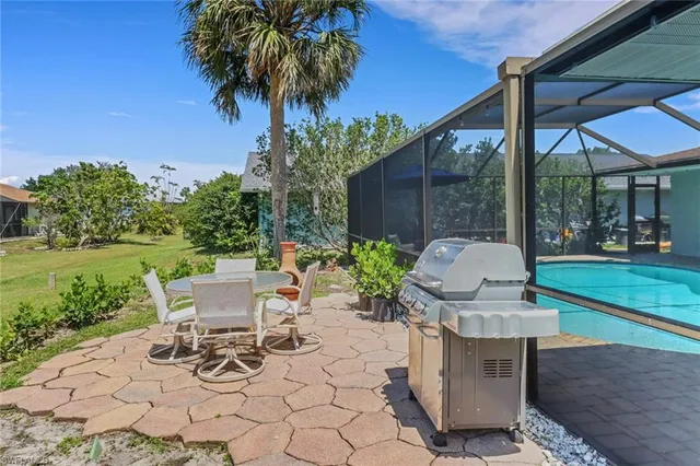 a view of a chair and table in backyard of the house