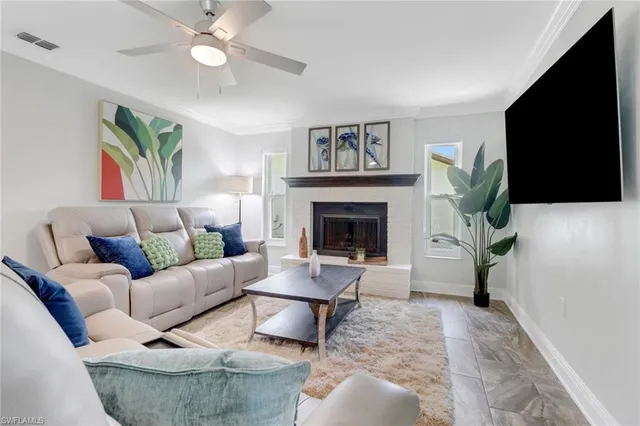 a living room with furniture a flat screen tv and a fireplace