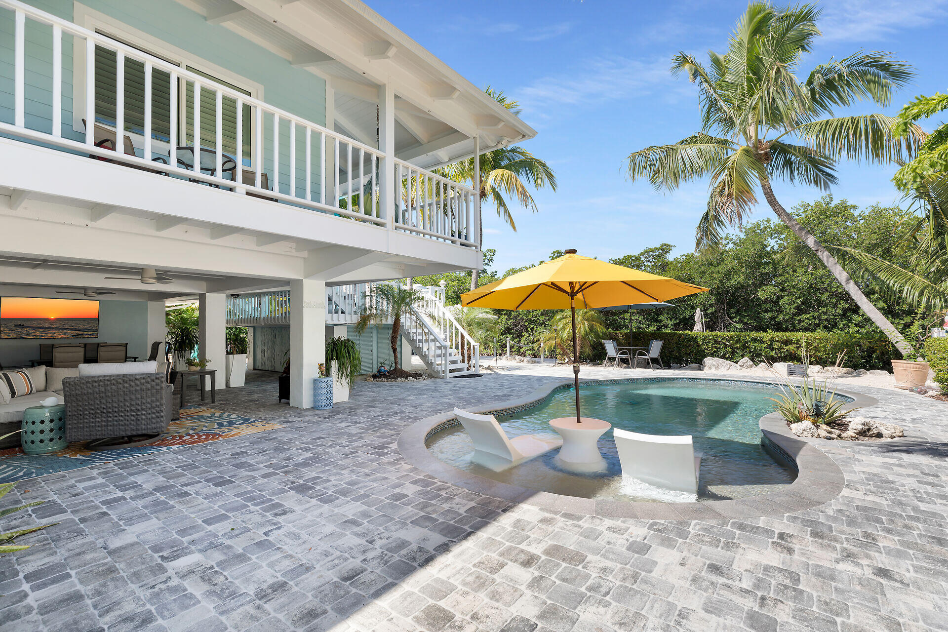 835 70th Street, Unit GULF Marathon, FL 33050 - Photo 9 of 46 a view of a patio with couches table and chairs under an umbrella
