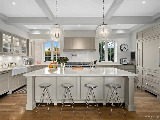 a kitchen with a dining table chairs cabinets and stainless steel appliances