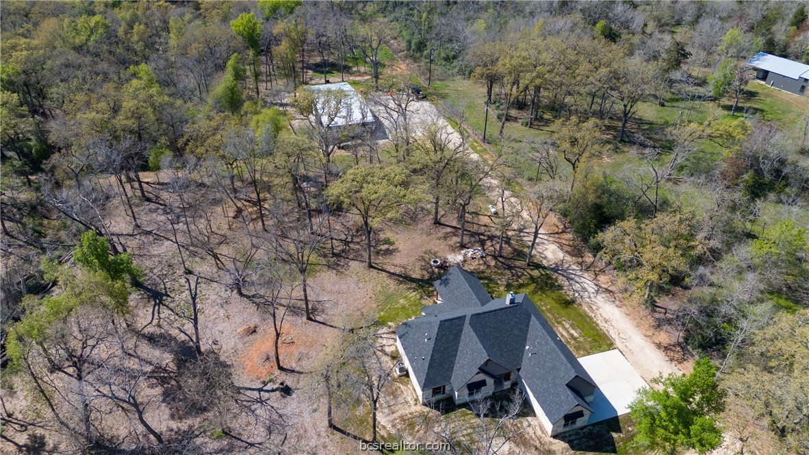 an aerial view of a house with a yard and trees