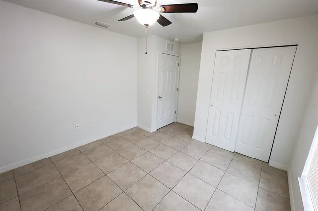 an empty room with fan and entrance
