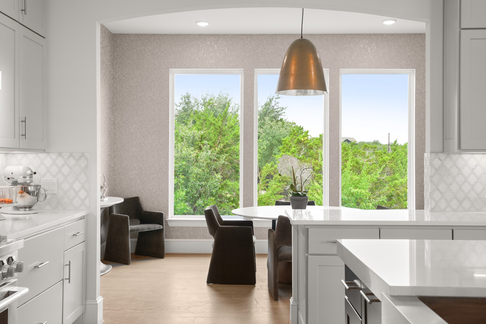104 Lodestone Cove Austin, TX 78738 - Photo 6 of 40 A sleek, open kitchen with abundant natural light offers a verdant outdoor vista.