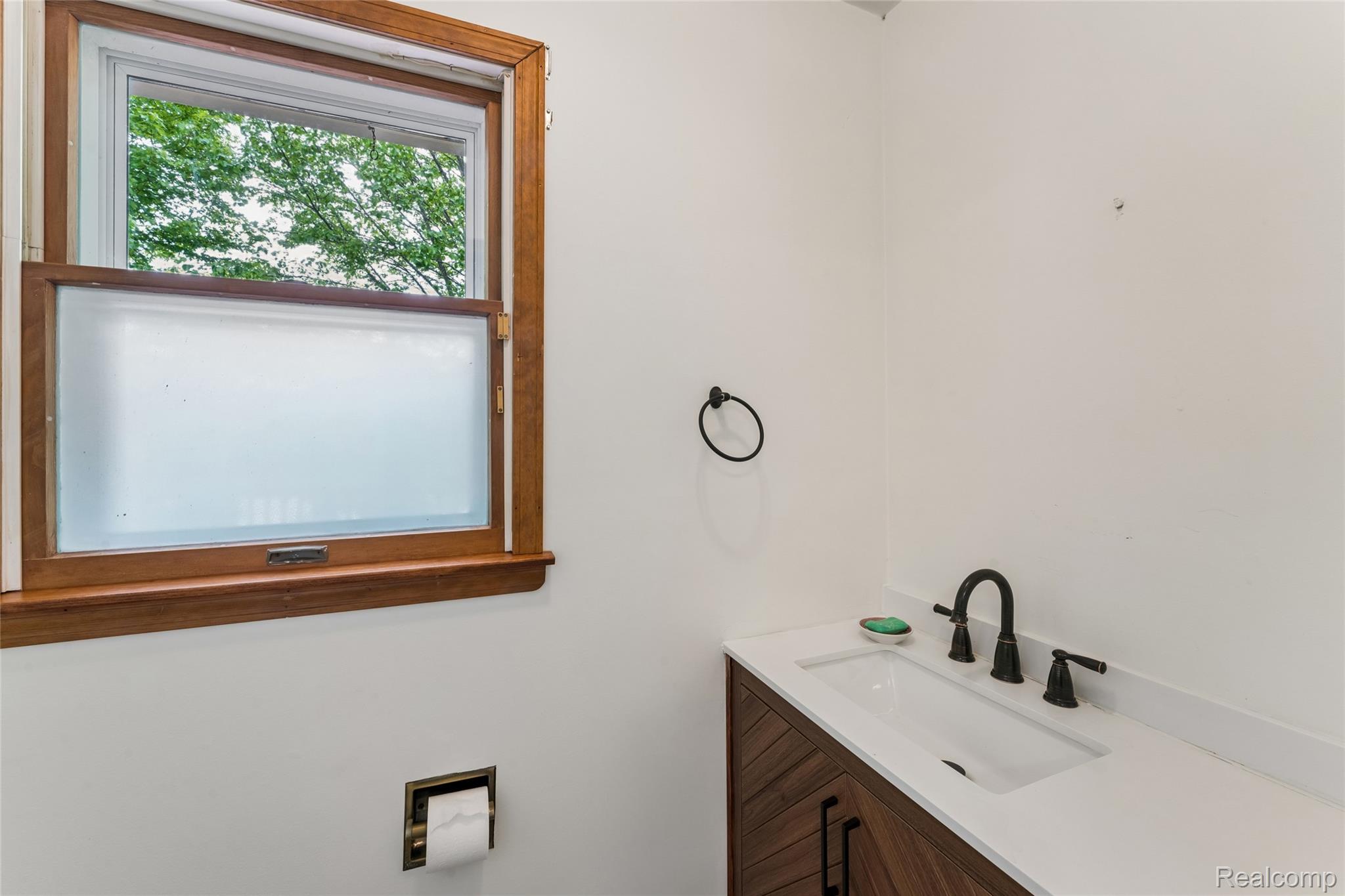 422 East Road Holly, MI 48442 - Photo 37 of 51 White vanity with an integrated rectangular sink, matte black faucet, and white countertop