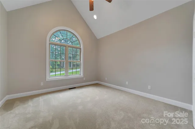 en empty room with windows and ceiling fan