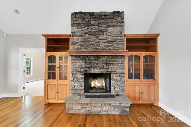 a living room with a fireplace and a wooden floor