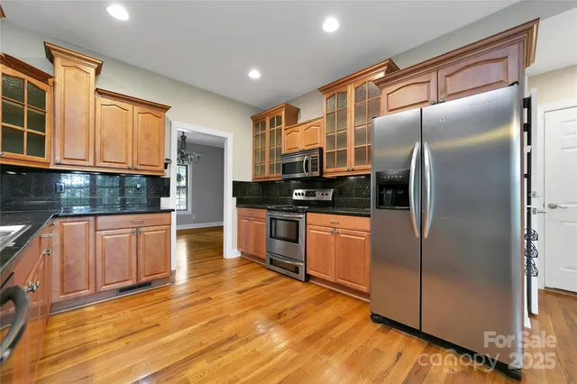 a kitchen with granite countertop a refrigerator and a stove top oven