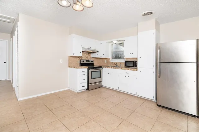 a kitchen with stainless steel appliances a refrigerator sink and cabinets