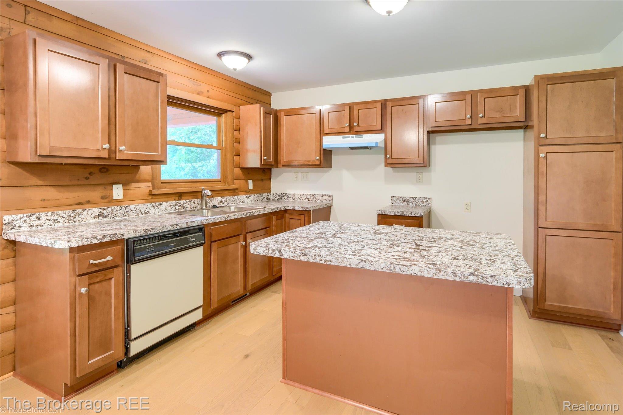 1077 Hadley Road Lapeer, MI 48446 - Photo 19 of 61 Kitchen featuring wood-finish cabinetry, light-toned wood-finish flooring, and speckled countertops