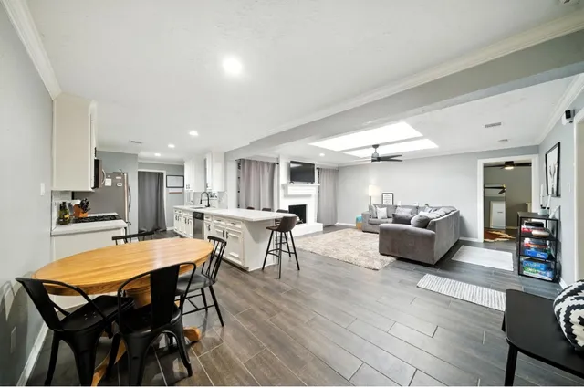 a living room with furniture a table and kitchen view