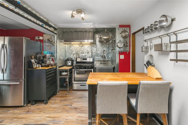 a kitchen with stainless steel appliances kitchen island granite countertop a table and chairs in it
