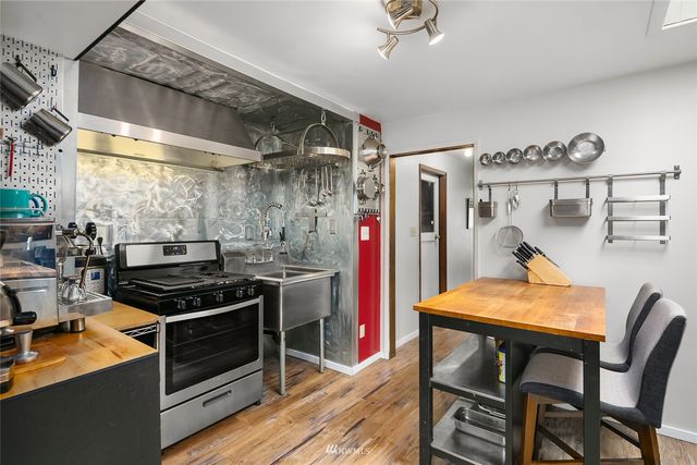 a kitchen with stainless steel appliances kitchen island a table and chairs