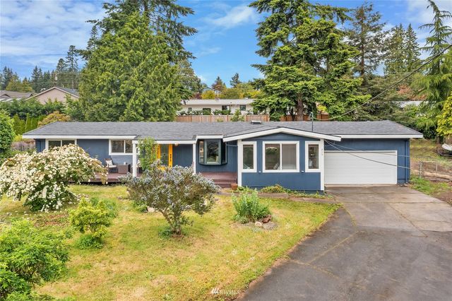 a front view of house with yard and trees in the background