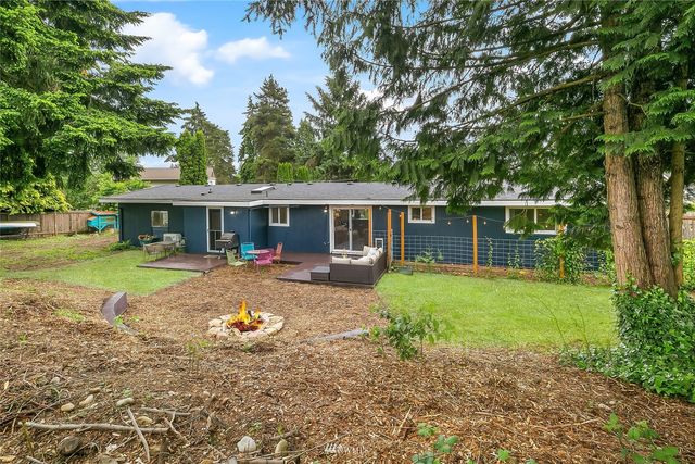 a view of a house with backyard and sitting area